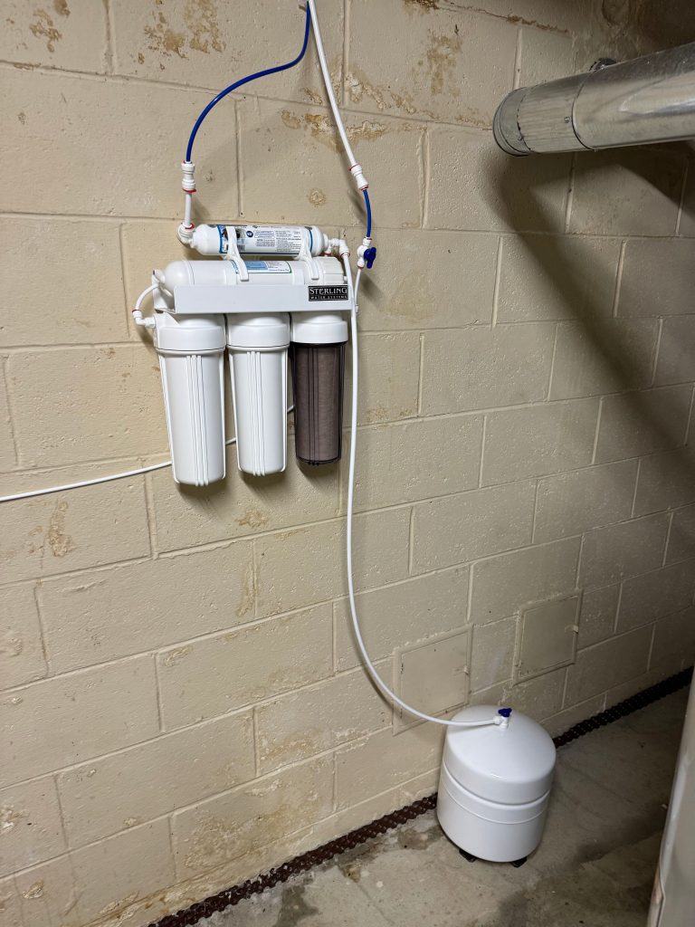 Reverse osmosis drinking water system with filter housings and storage tank installed by Rochester Water Conditioning for homes in Troy, MI